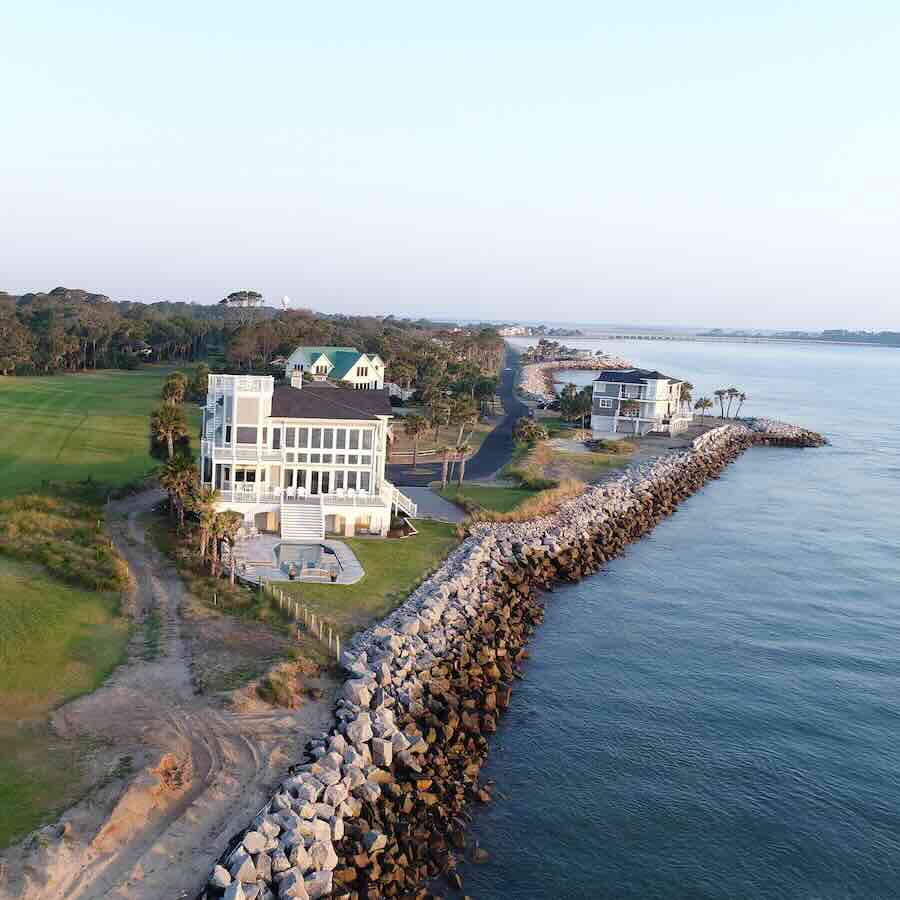 Coastal homes by the ocean with rocky shoreline.