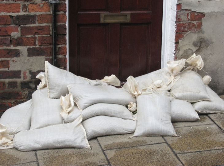 Sandbags stacked to block floodwaters at door.