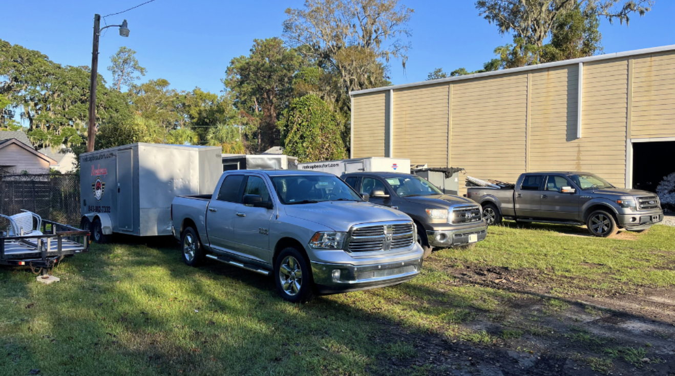 Pickup trucks and trailers parked outside warehouse
