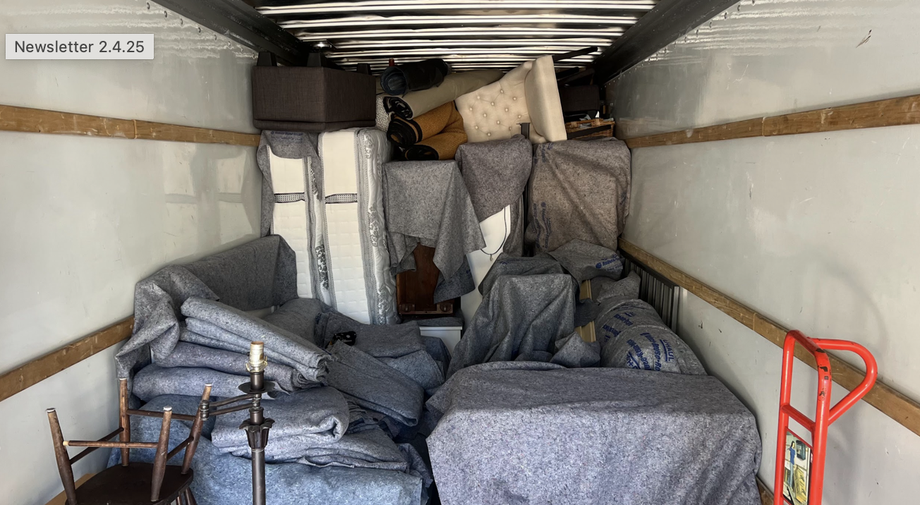 Moving truck packed with wrapped furniture.