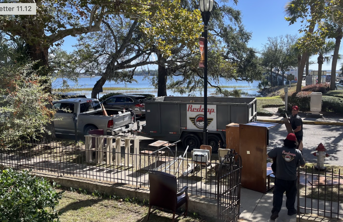 Workers loading furniture into truck by water.