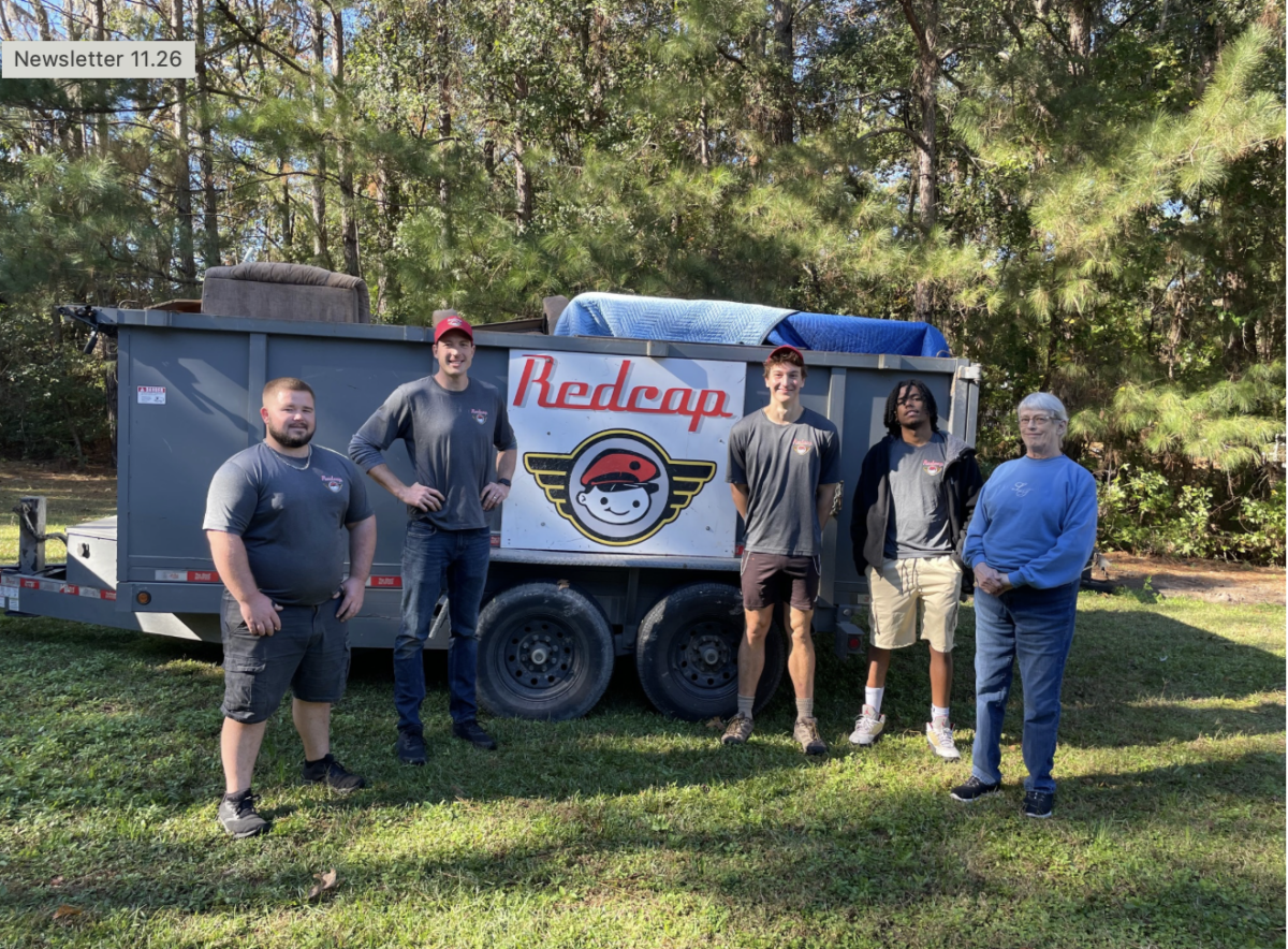 Group of people by Redcap trailer in woods