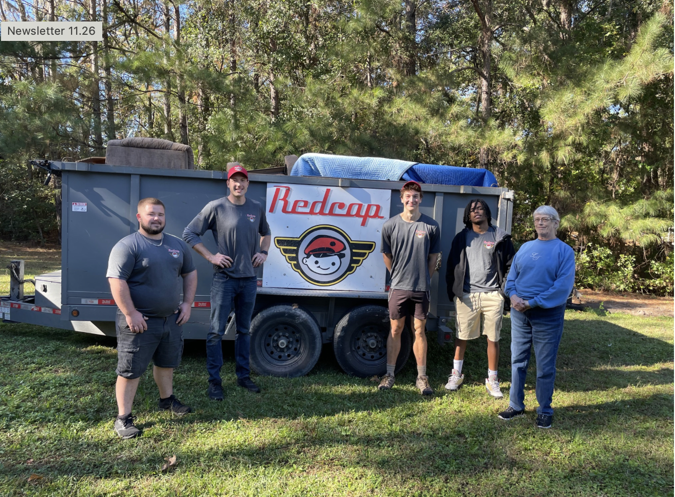 Group of people by Redcap trailer in woods