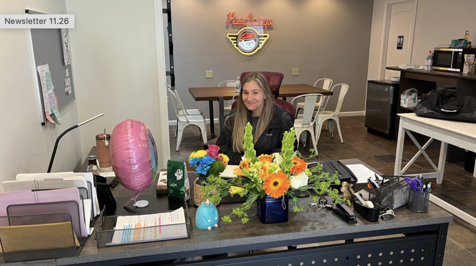 Woman at desk with flowers and balloon