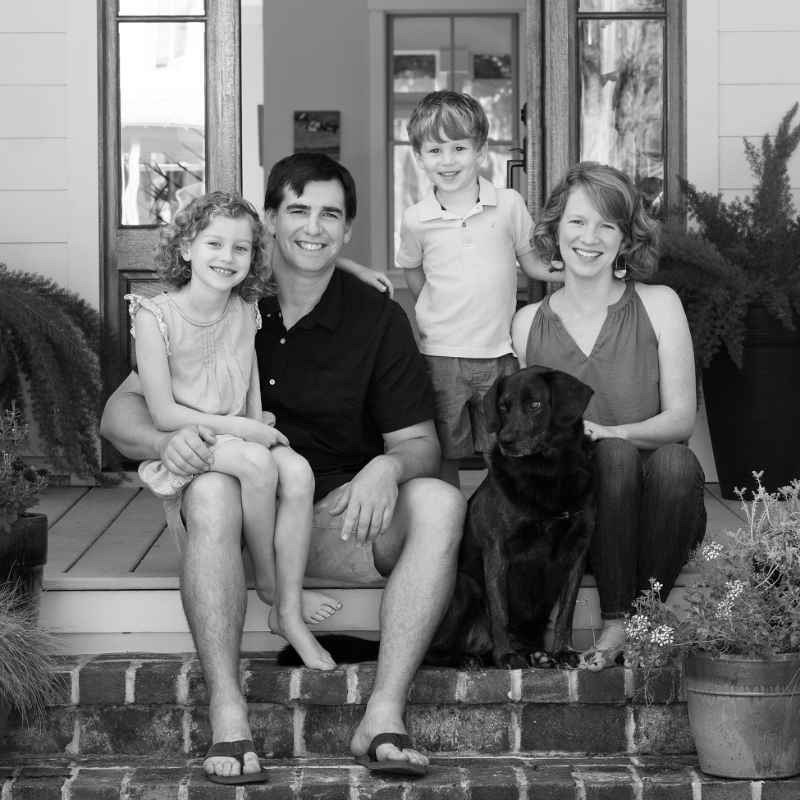 Family sitting together on porch with dog