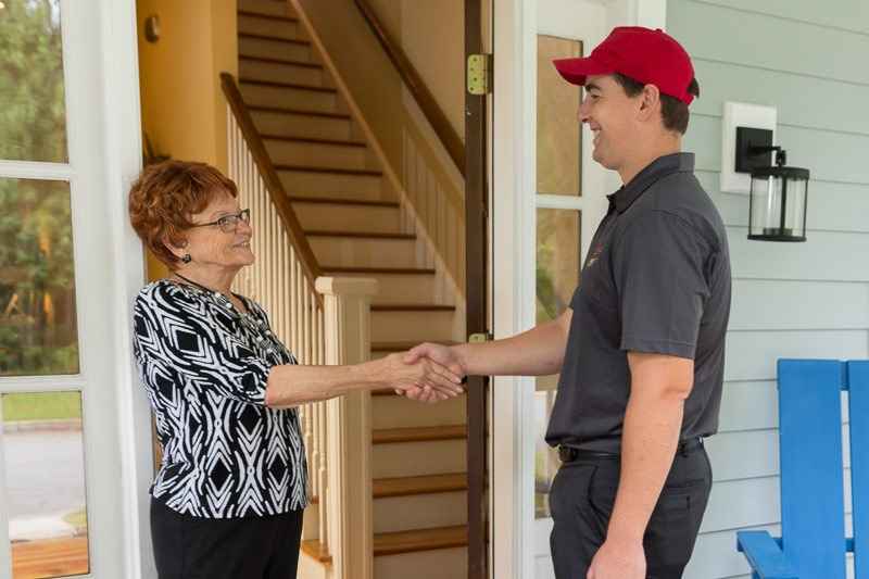 Elderly woman shaking hands with delivery man